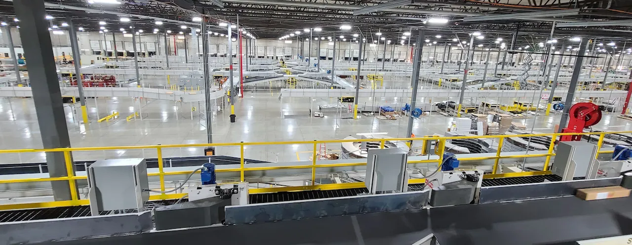 Overhead view of a parcel sortation system with curved chutes in a distribution center