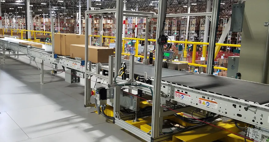 Powered roller conveyor moving boxes through a parcel warehouse